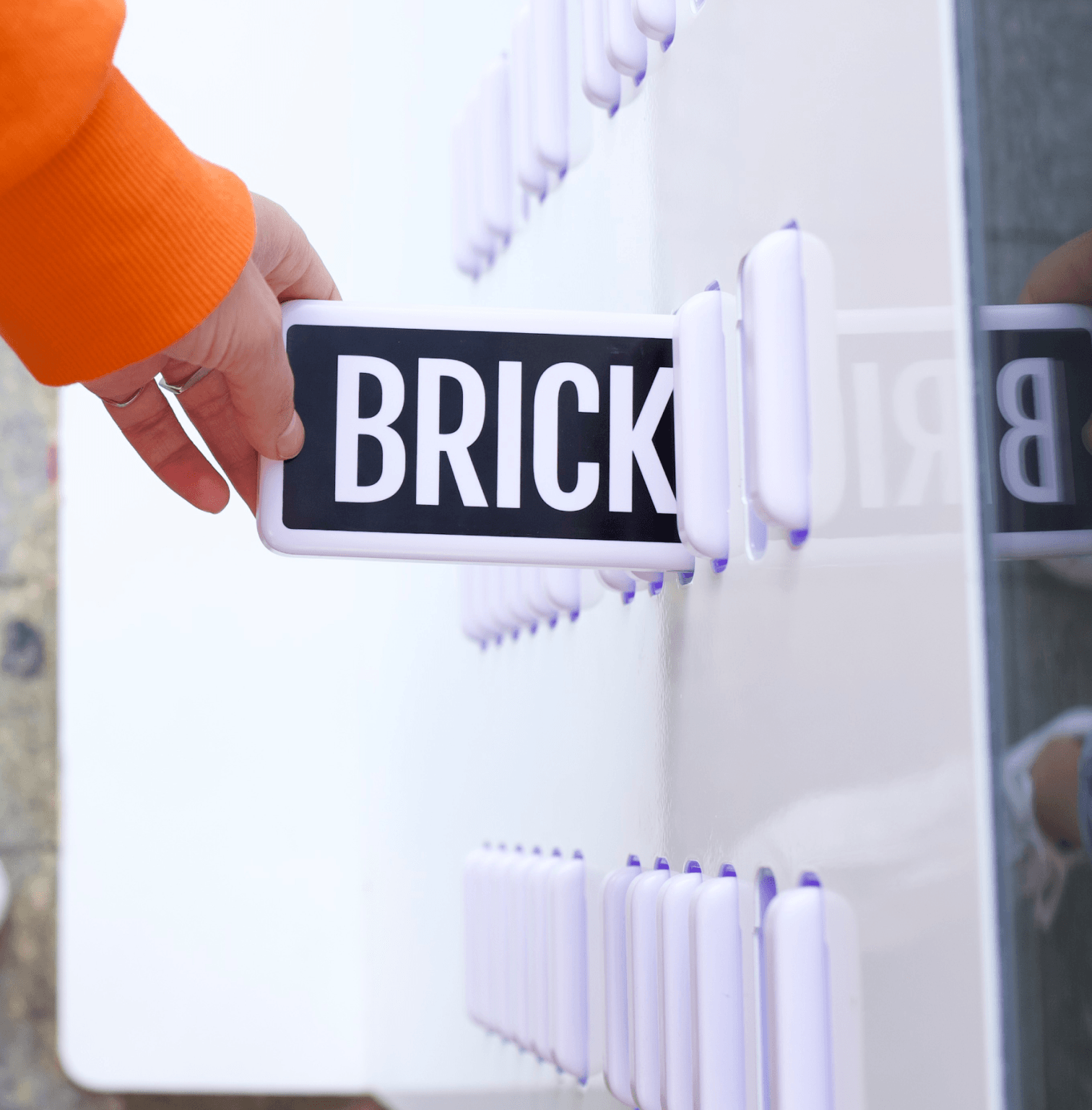 A hand retrieving a Brick power bank from a station